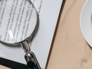 Magnifying glass on top of a printed book or essay